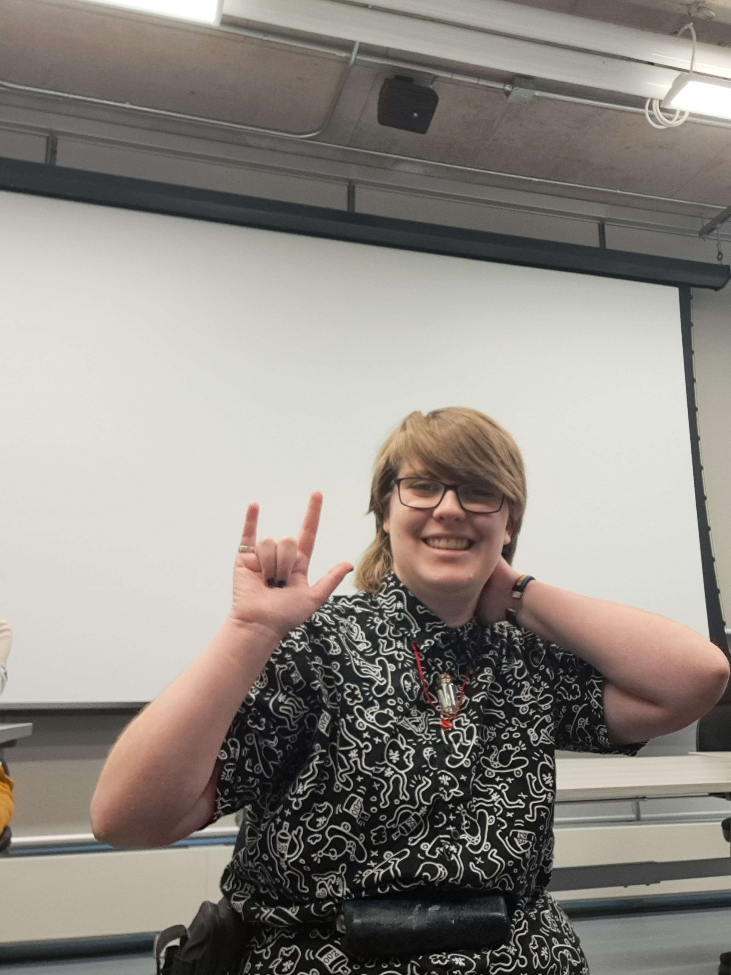 demonstrating how a picture can be taken without holding the device<br>also includes a sign in ASL to acknowledge deaf people